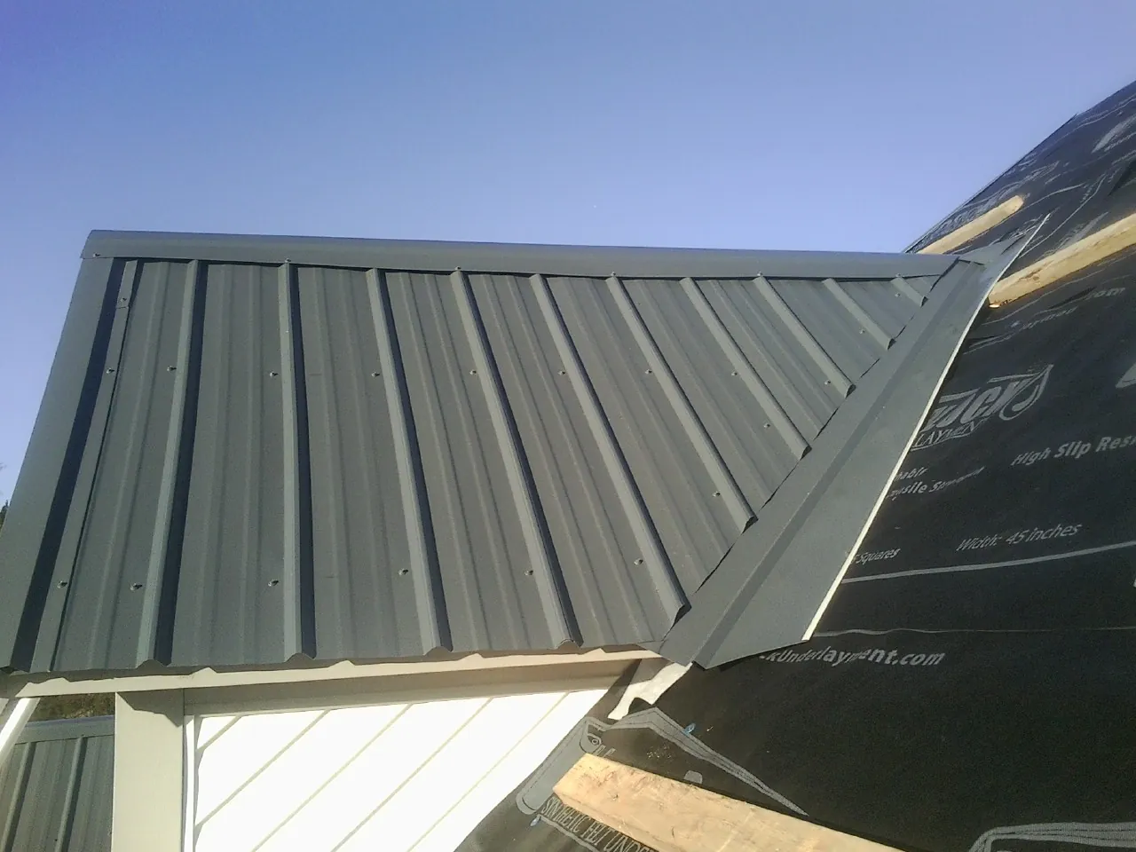 Gray metal roof panels going on over a garage gable in Brandywine