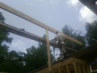 Carpenter setting a ridge beam over a new addition frame — Ice Dam Removal by Roofing Brothers in Brandywine