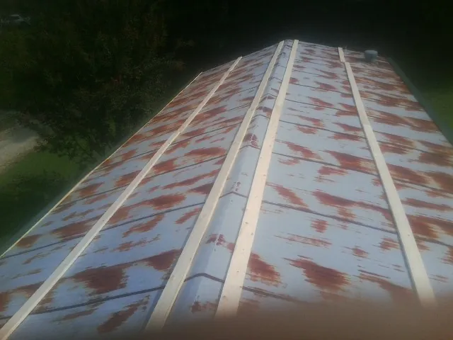 Rusted metal roof panels with new wood purlins before replacement — Storm Damage Roof Repair in Brandywine by Roofing Brothers