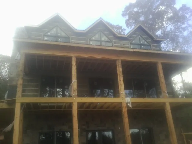 Dormers and porch framing on a large log home under construction — Roof Coating work by our crew in Brandywine